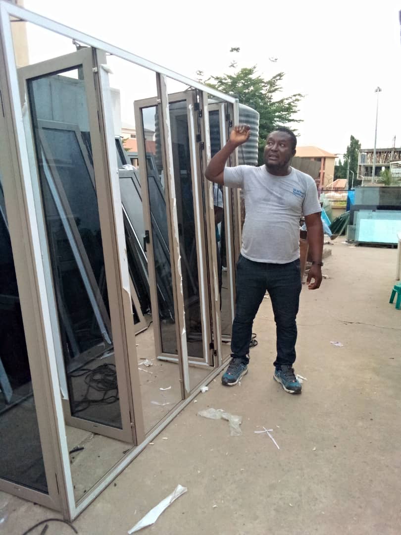 OSAFURE team member beside tall aluminium-framed glass panels