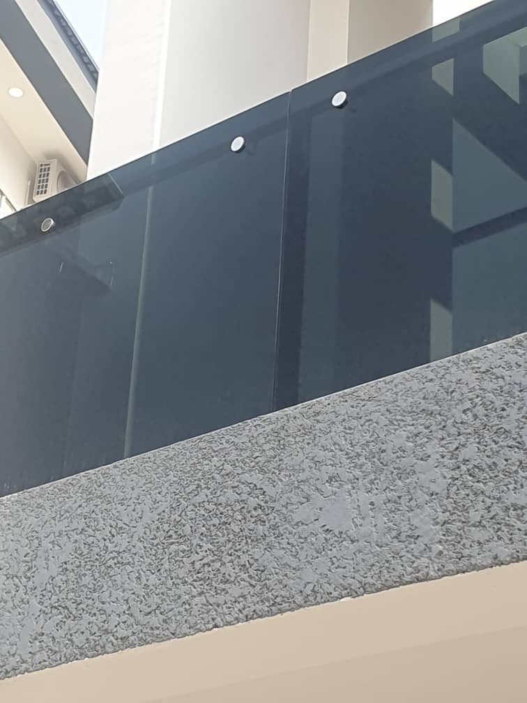 Close-up of a tinted glass balustrade with steel fixings