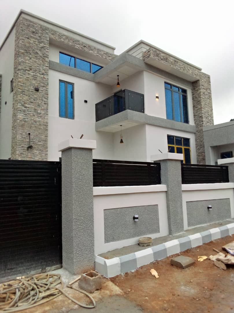 House front with a dark glass balcony and stone-clad columns