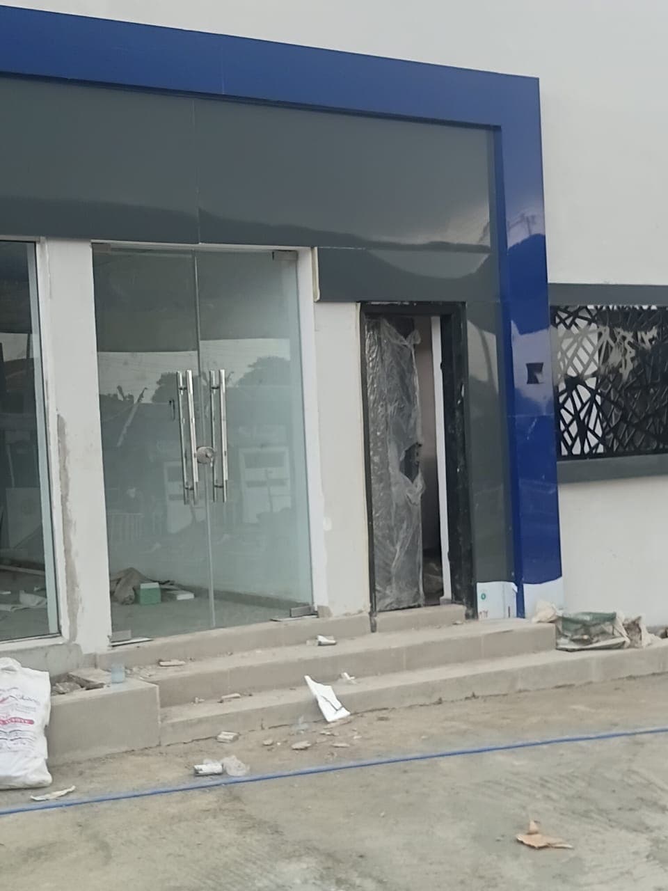 Glass shopfront with double glass doors under a blue fascia