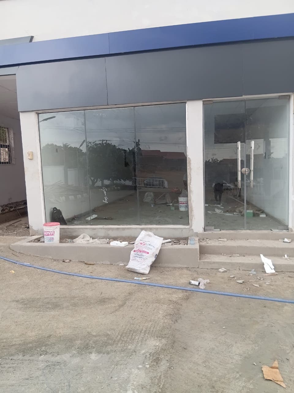 Glass shopfront under a blue and grey cladded fascia