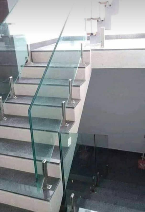 Glass staircase railing held by stainless-steel posts