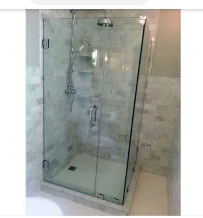 Frameless glass shower cubicle in a tiled bathroom