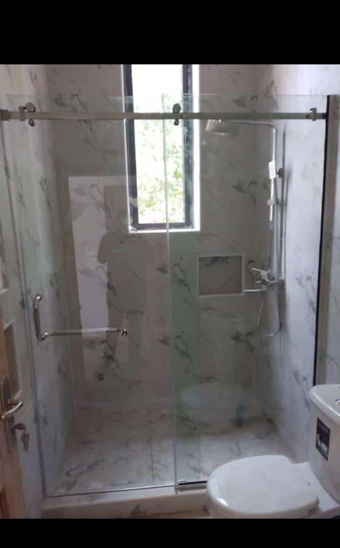 Sliding glass shower screen in a marble-tiled bathroom