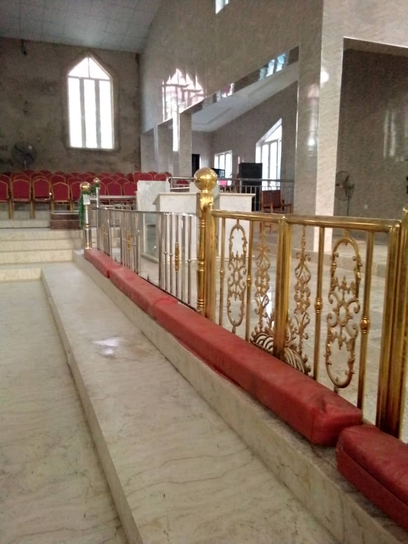 Decorative gold-finish railing along a raised platform in a large hall