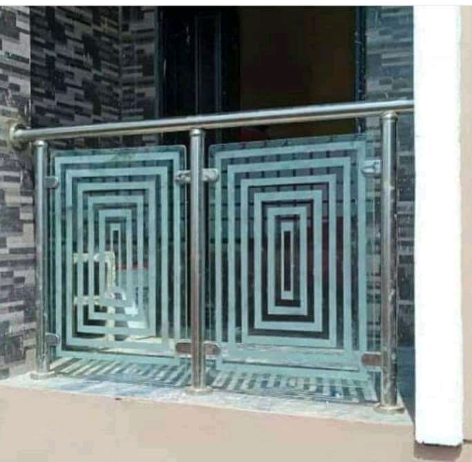 Stainless-steel railing with patterned glass panels at a building entrance