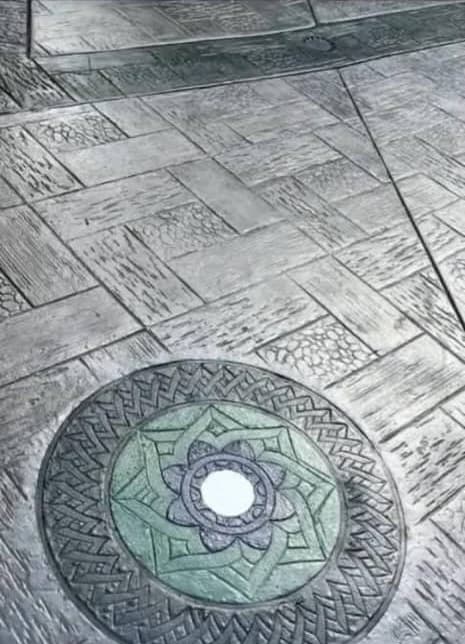 Grey stamped concrete with a green rose medallion