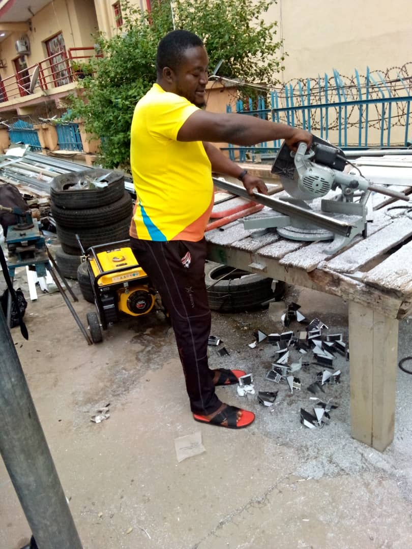 OSAFURE team member cutting aluminium with a mitre saw