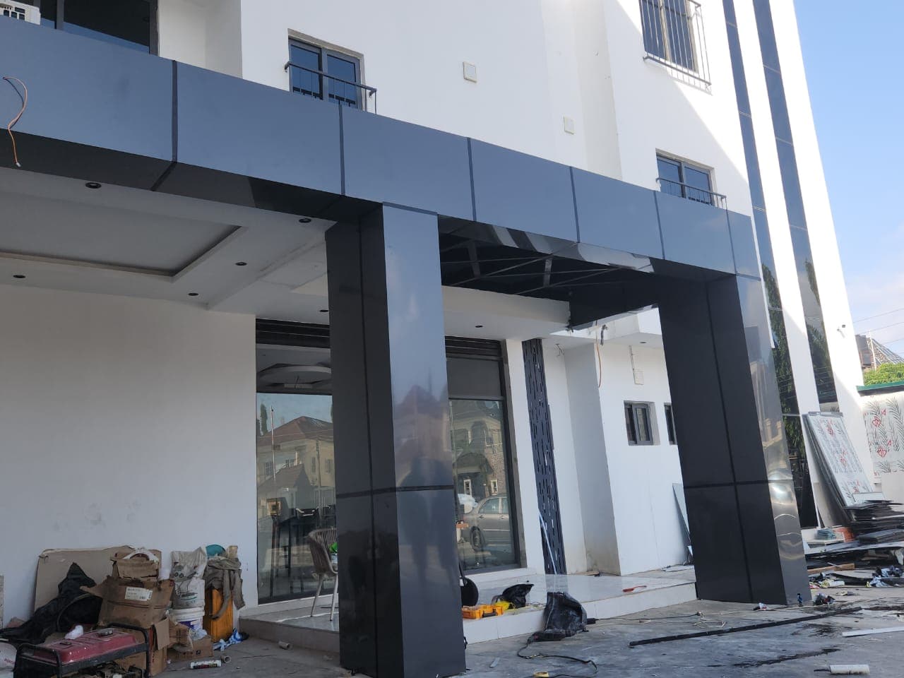 Building entrance with dark glossy cladding on columns and canopy