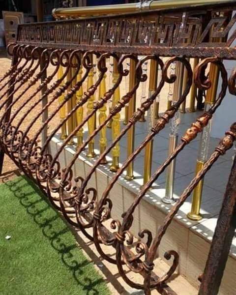 Wrought-iron railing with scrollwork and gold-finish balusters